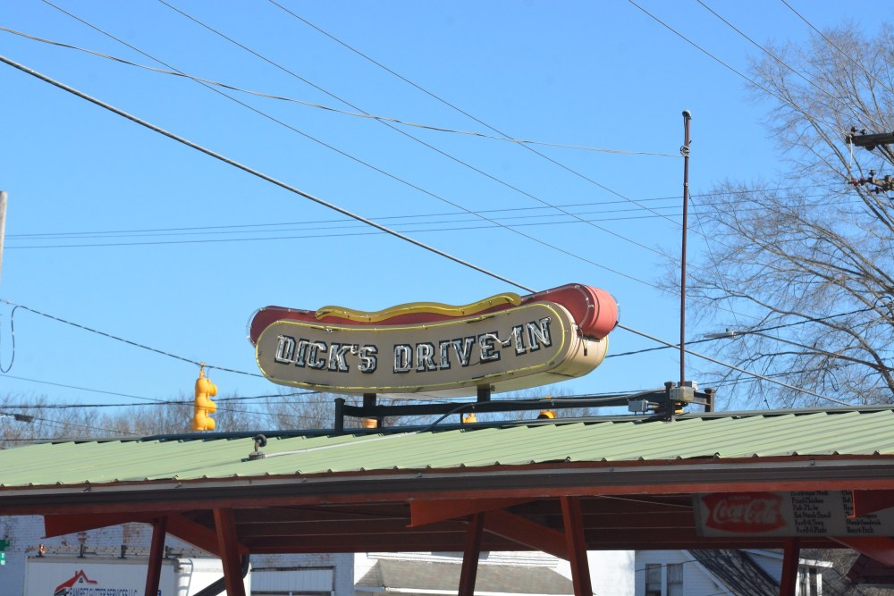 a sign shaped like a hot dog that says dick's drive-in